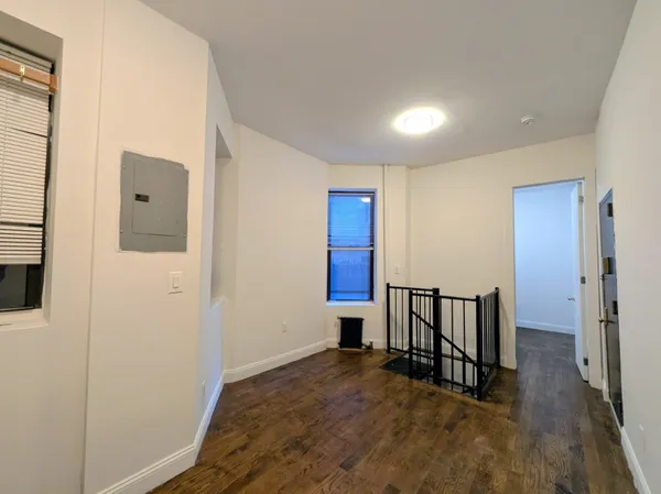 a view of a hallway with wooden floor and staircase