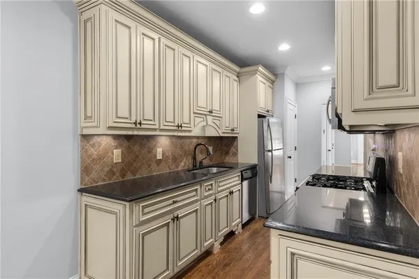 a kitchen with stainless steel appliances granite countertop a sink stove and cabinets