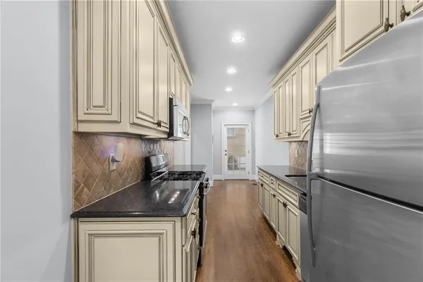 a kitchen with stainless steel appliances granite countertop a stove a sink and a refrigerator