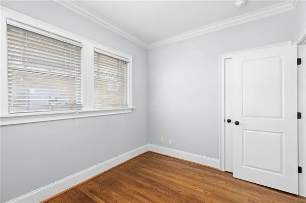 a view of a hallway with wooden floor and a living room