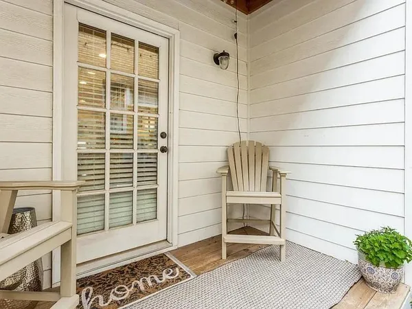 a view of a patio with table and chairs and wooden fence