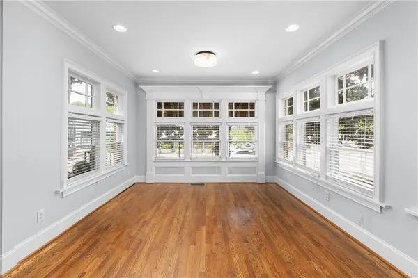 a view of empty room with wooden floor and fan