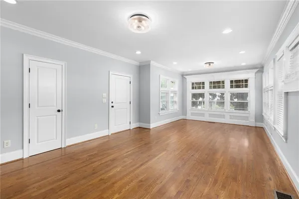 a view of empty room with wooden floor and windows