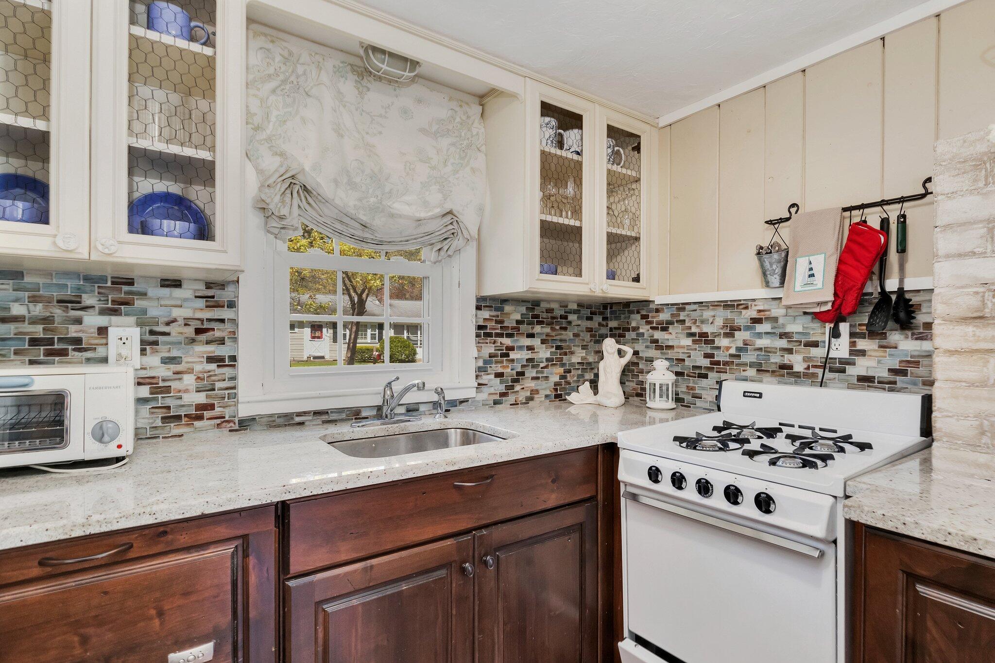 28 Swan Lake Road West Yarmouth, MA 02673 - Photo 12 of 44 a kitchen with a sink stove and cabinets
