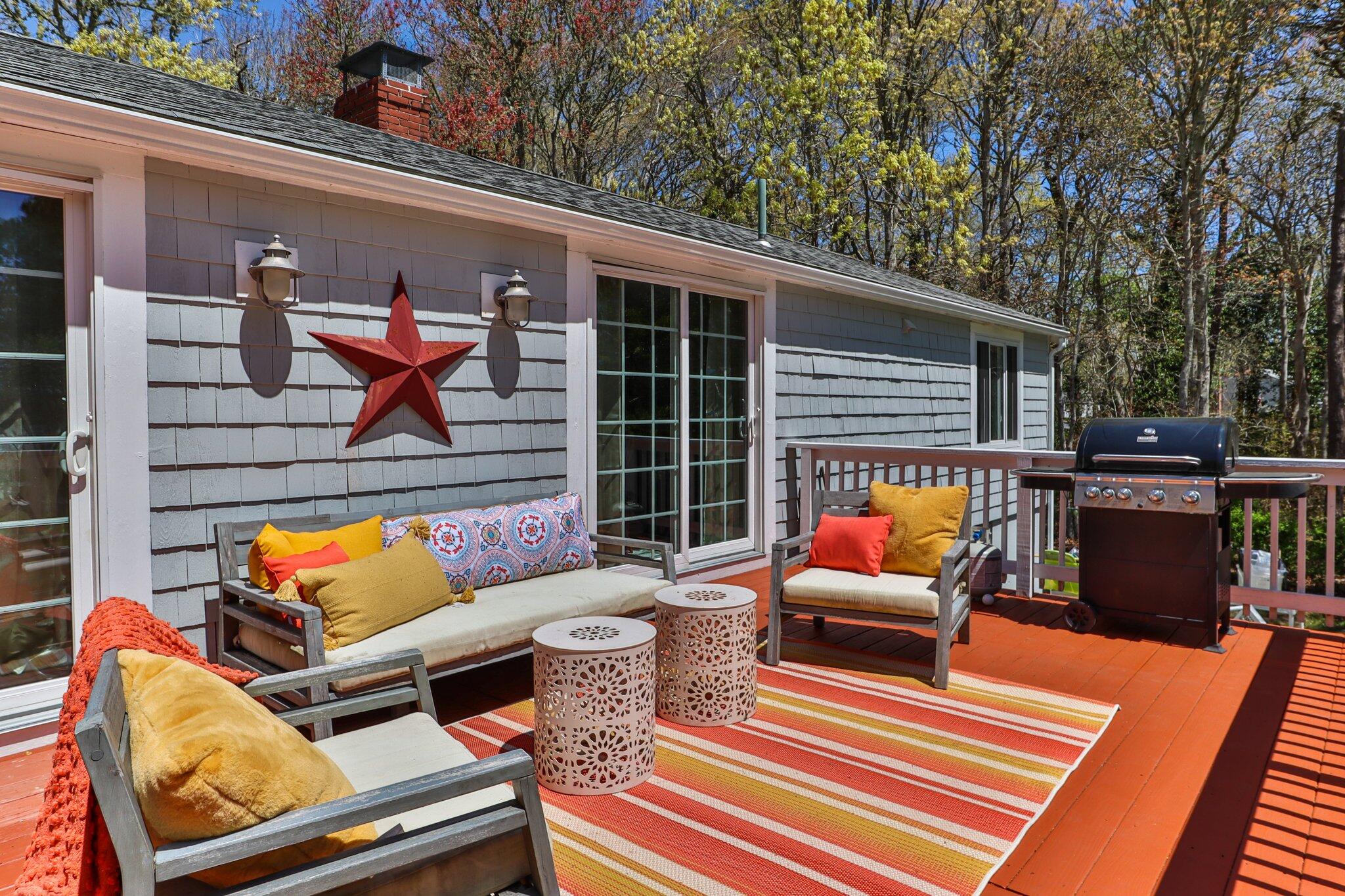 28 Swan Lake Road West Yarmouth, MA 02673 - Photo 28 of 44 a backyard of a house with sofas table and chairs
