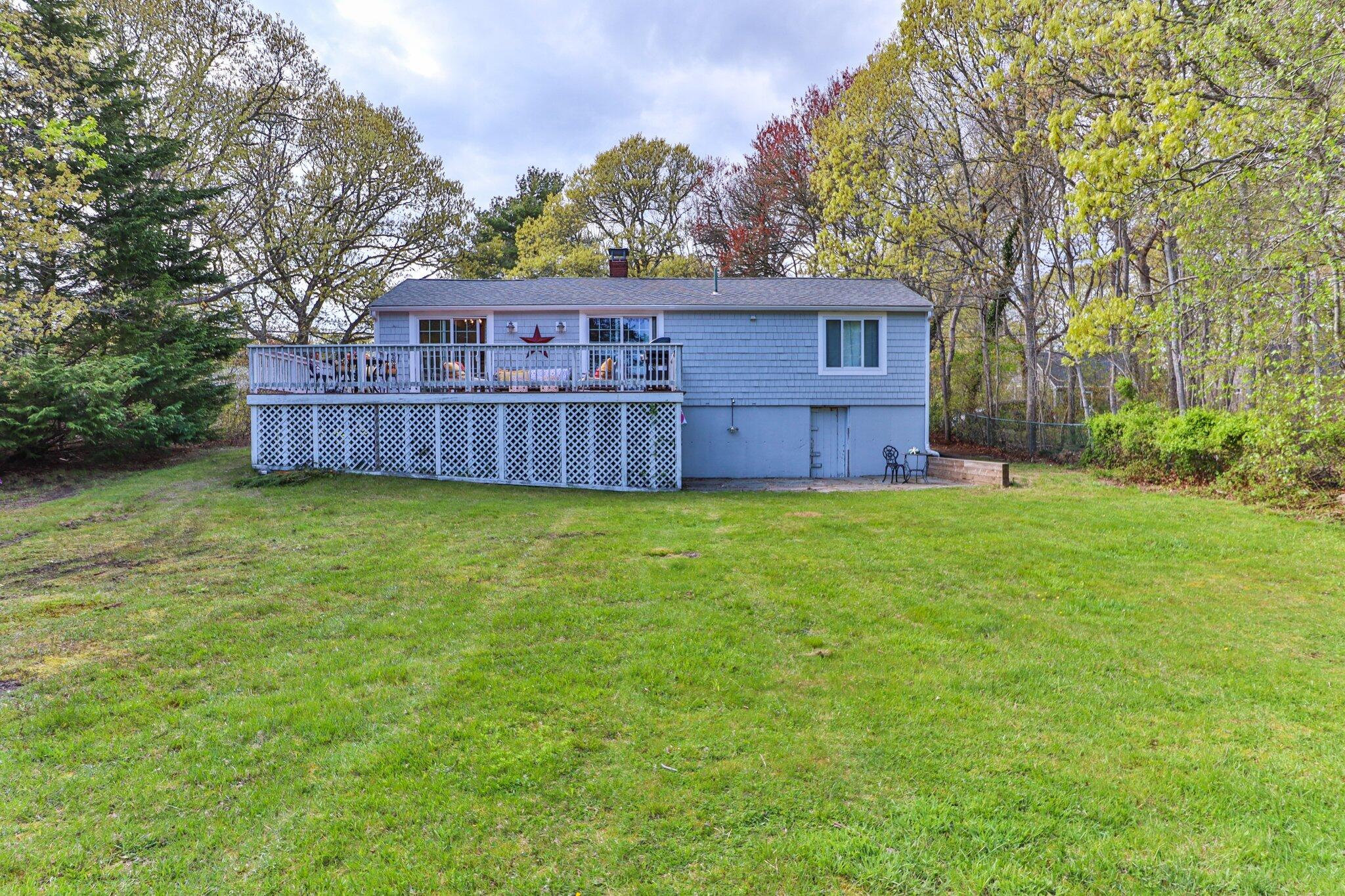 28 Swan Lake Road West Yarmouth, MA 02673 - Photo 42 of 44 a view of a house with a big yard and large trees