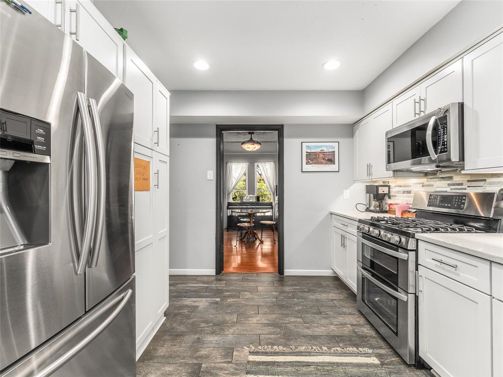 4446 Thunder Road Dallas, TX 75244 - Photo 11 of 39 Kitchen with stainless steel appliances, white cabinetry, dark wood-style flooring, recessed lighting, and decorative backsplash