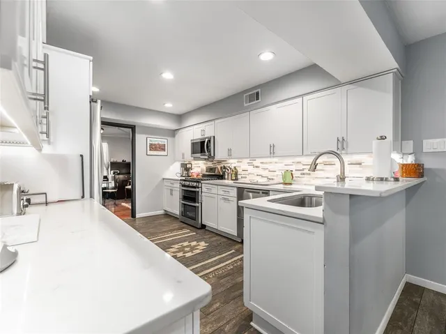 a kitchen with a sink a stove and cabinets