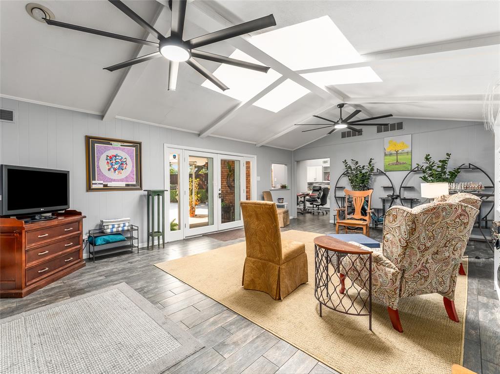 4446 Thunder Road Dallas, TX 75244 - Photo 15 of 39 Living area with ceiling fan, wood finished floors, wood walls, and a skylight