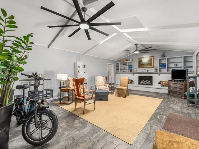 a living room with furniture a fireplace a chandelier and a flat screen tv
