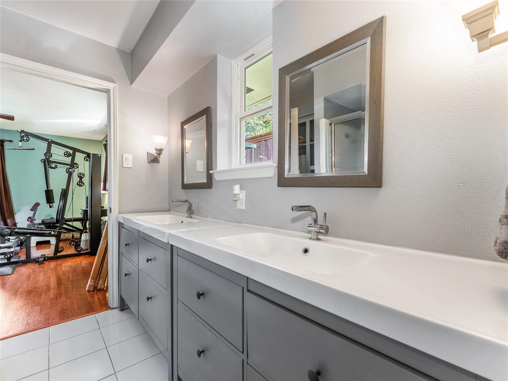 4446 Thunder Road Dallas, TX 75244 - Photo 20 of 39 Bathroom with double vanity, light tile patterned floors, and an enclosed shower
