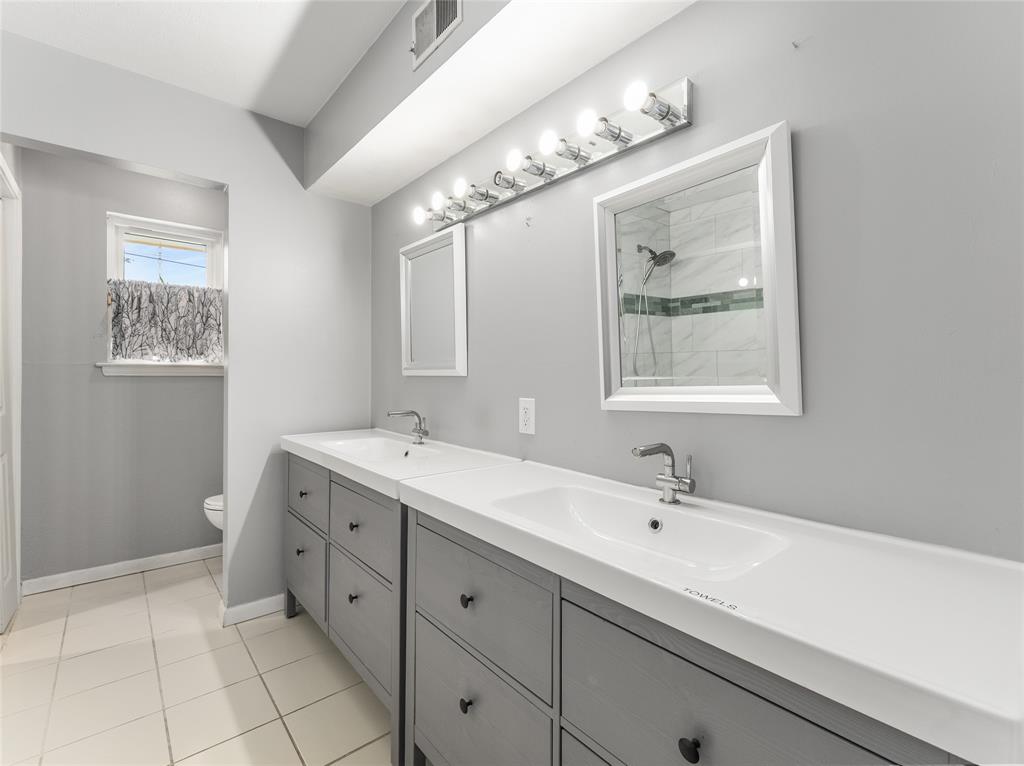 4446 Thunder Road Dallas, TX 75244 - Photo 25 of 39 Full bath featuring double vanity, tiled shower, and light tile patterned floors