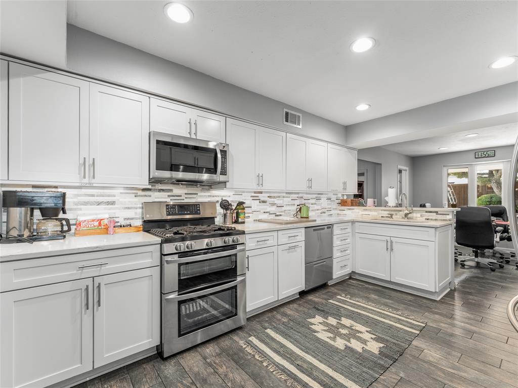 4446 Thunder Road Dallas, TX 75244 - Photo 9 of 39 Kitchen featuring stainless steel appliances, white cabinets, decorative backsplash, a peninsula, and recessed lighting