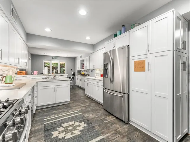 a kitchen with white cabinets and white appliances