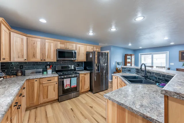 a kitchen with stainless steel appliances granite countertop a sink stove and refrigerator