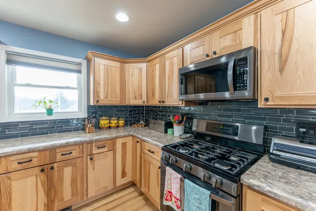 a kitchen with stainless steel appliances granite countertop a sink stove and microwave