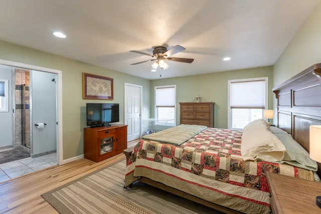 a bedroom with a bed and a dresser with mirror