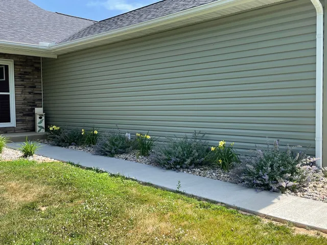 a view of house with backyard and plants