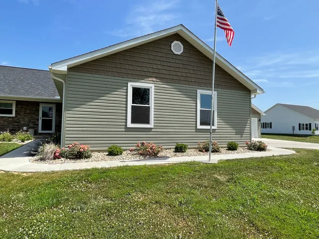 a front view of house with yard and trees in the background