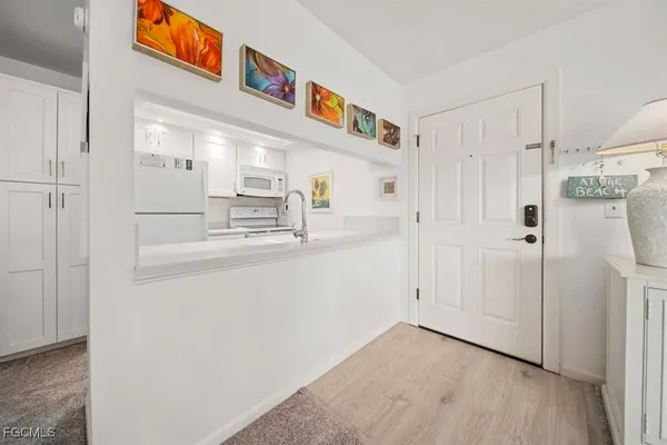 a kitchen with white cabinets and refrigerator