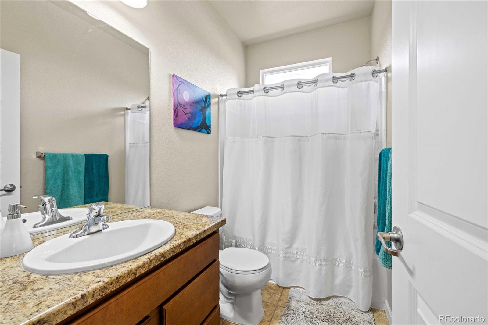 1030 Wagon Train Drive Milliken, CO 80543 - Photo 27 of 49 a bathroom with a granite countertop sink toilet and shower