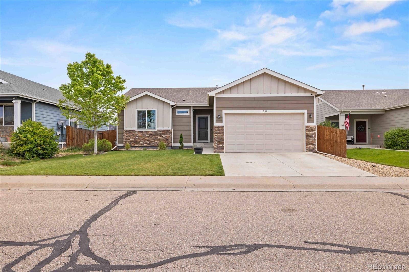 1030 Wagon Train Drive Milliken, CO 80543 - Photo 3 of 49 a front view of a house with a yard and garage