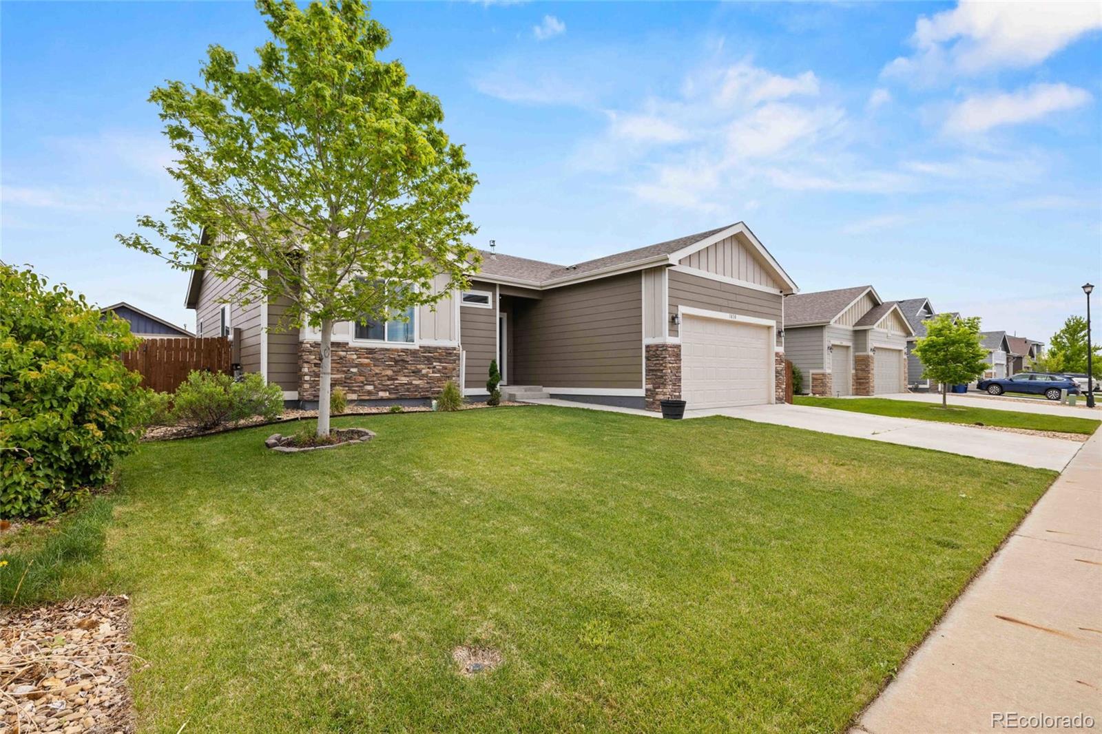 1030 Wagon Train Drive Milliken, CO 80543 - Photo 4 of 49 a front view of house with yard and trees