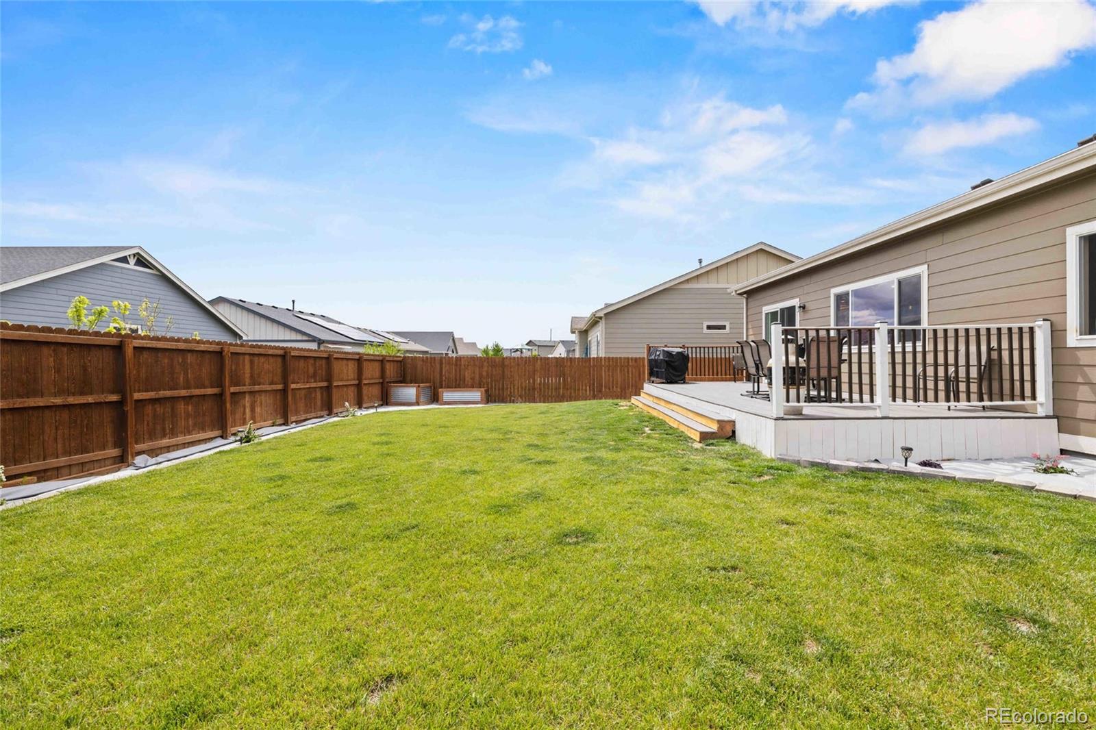 1030 Wagon Train Drive Milliken, CO 80543 - Photo 42 of 49 a view of a white house with a big yard and large trees