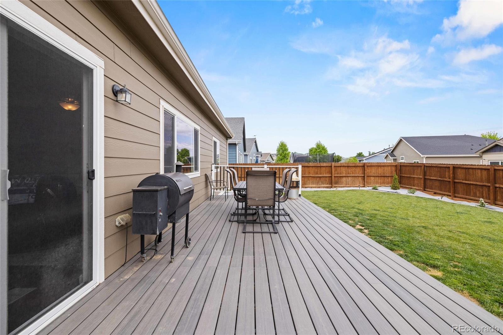 1030 Wagon Train Drive Milliken, CO 80543 - Photo 43 of 49 a view of a deck with table and chairs and wooden floor