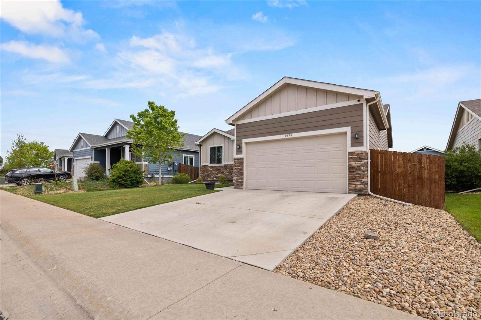 1030 Wagon Train Drive Milliken, CO 80543 - Photo 5 of 49 a front view of a house with a yard and garage
