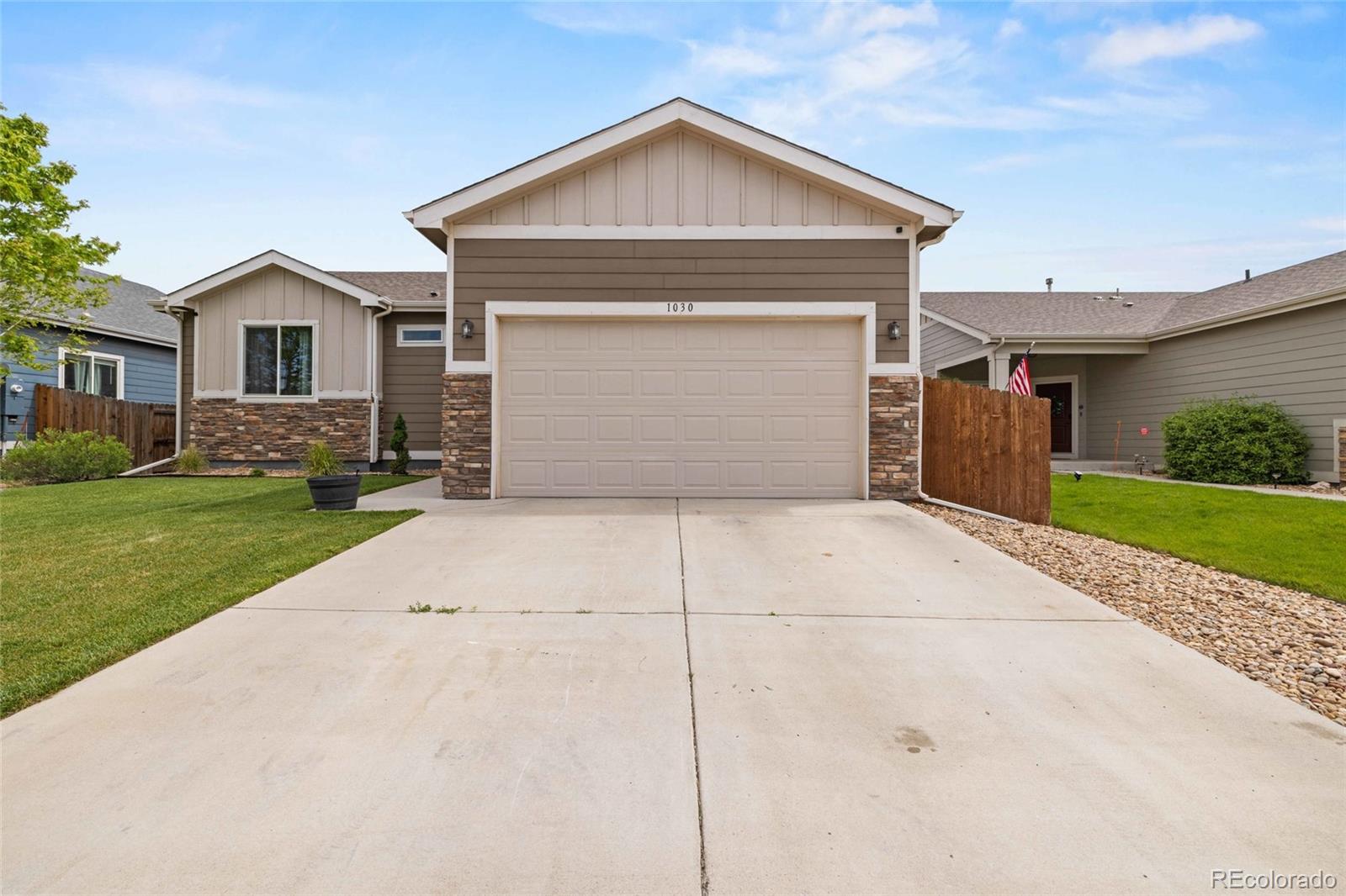 1030 Wagon Train Drive Milliken, CO 80543 - Photo 6 of 49 a front view of a house with a yard and garage