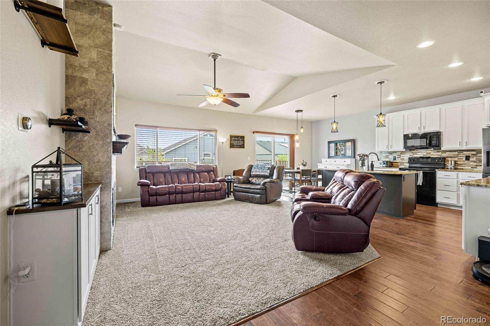1030 Wagon Train Drive Milliken, CO 80543 - Photo 9 of 49 a living room with furniture and a flat screen tv