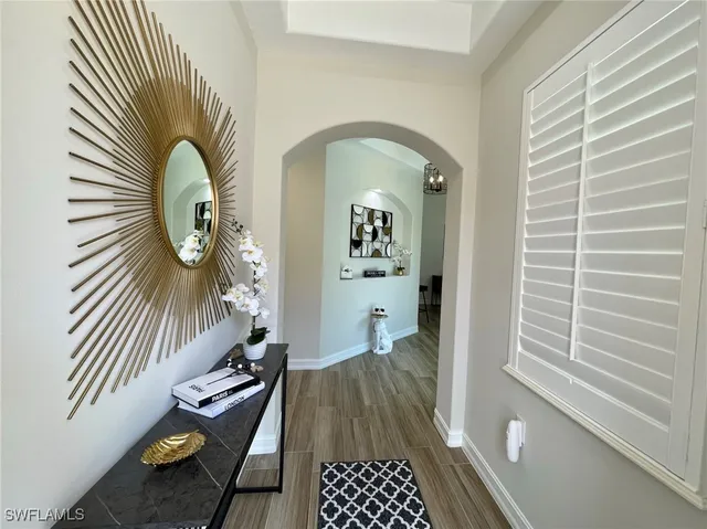 a view of a hallway with wooden floor and a bathroom