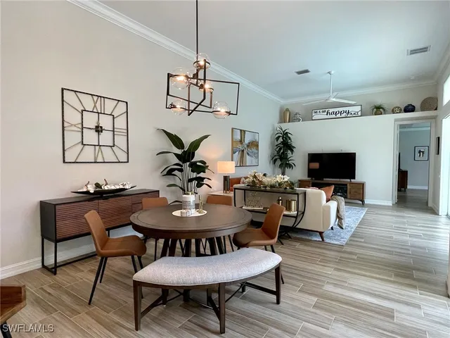 a view of a dining room with furniture a chandelier and wooden floor
