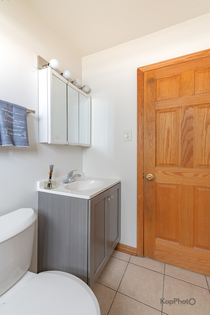 6914 West 65th Street, Unit 7 Chicago, IL 60638 - Photo 26 of 28 a bathroom with a sink a toilet and mirror