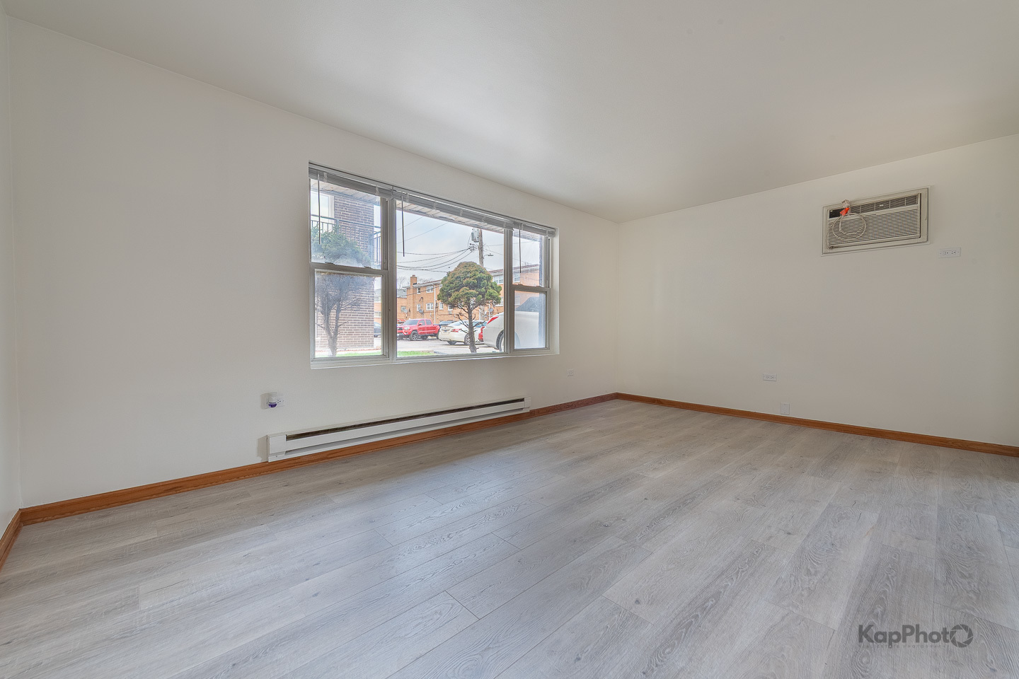 6914 West 65th Street, Unit 7 Chicago, IL 60638 - Photo 5 of 28 an empty room with wooden floor and windows