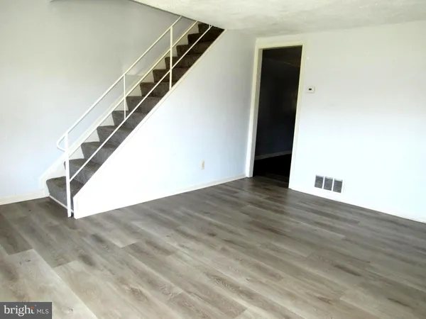 a view of a big room with wooden floor and stairs