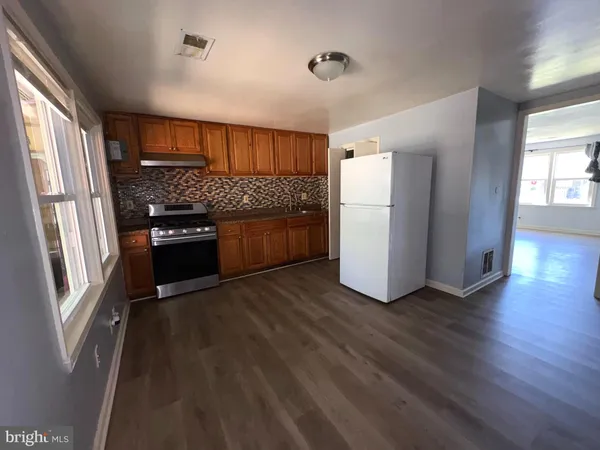 a kitchen with a refrigerator and a stove top oven