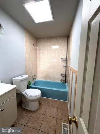 a bathroom with a sink a toilet a mirror and window