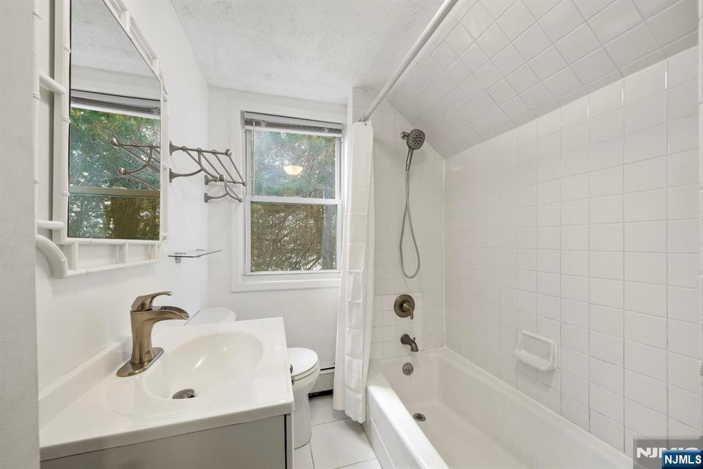 20 Columbus Avenue, Unit 2 Closter, NJ 07624 - Photo 4 of 15 a bathroom with a sink a toilet and shower