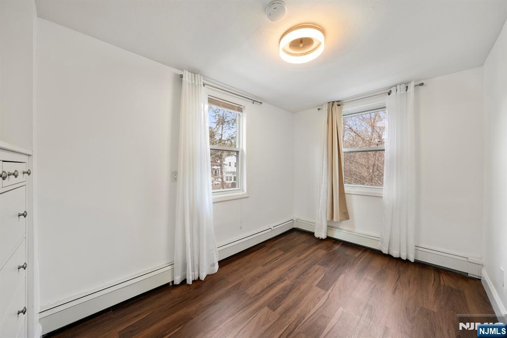 20 Columbus Avenue, Unit 2 Closter, NJ 07624 - Photo 8 of 15 an empty room with wooden floor and windows