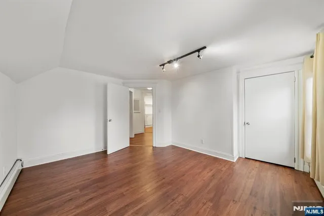 a view of an empty room with wooden floor