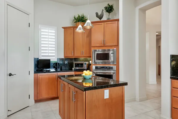 a kitchen with granite countertop a sink and cabinets