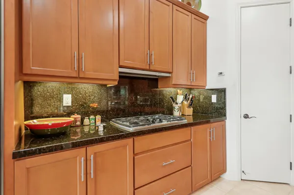 a kitchen with granite countertop a refrigerator a stove and a cabinets
