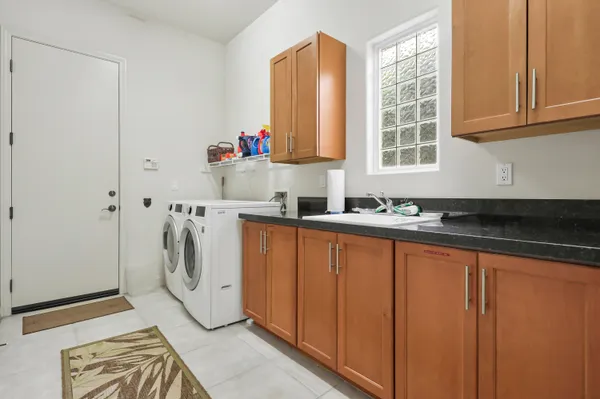 a spacious bedroom with a bed a table chair and a chandelier