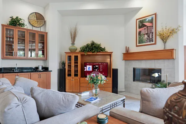 a living room with furniture kitchen view and large windows
