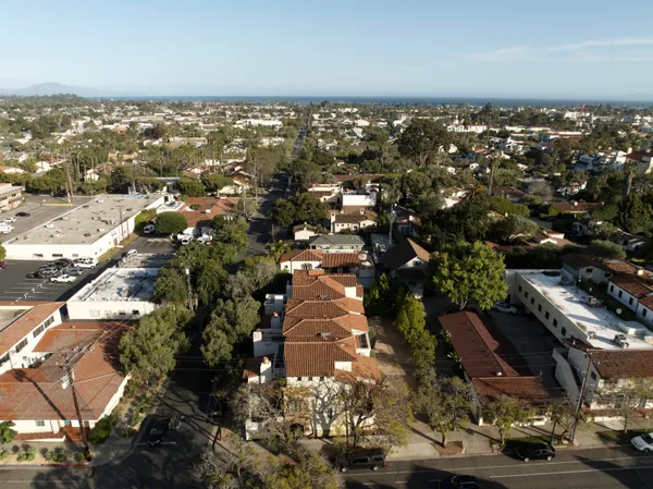 an aerial view of residential house with parking and trees