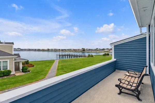 a view of a lake with a big yard potted plants and large tree