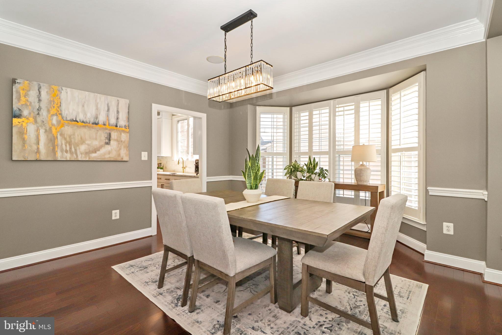 22773 Highcrest Circle Brambleton, VA 20148 - Photo 14 of 40 a dining room with furniture a chandelier and wooden floor