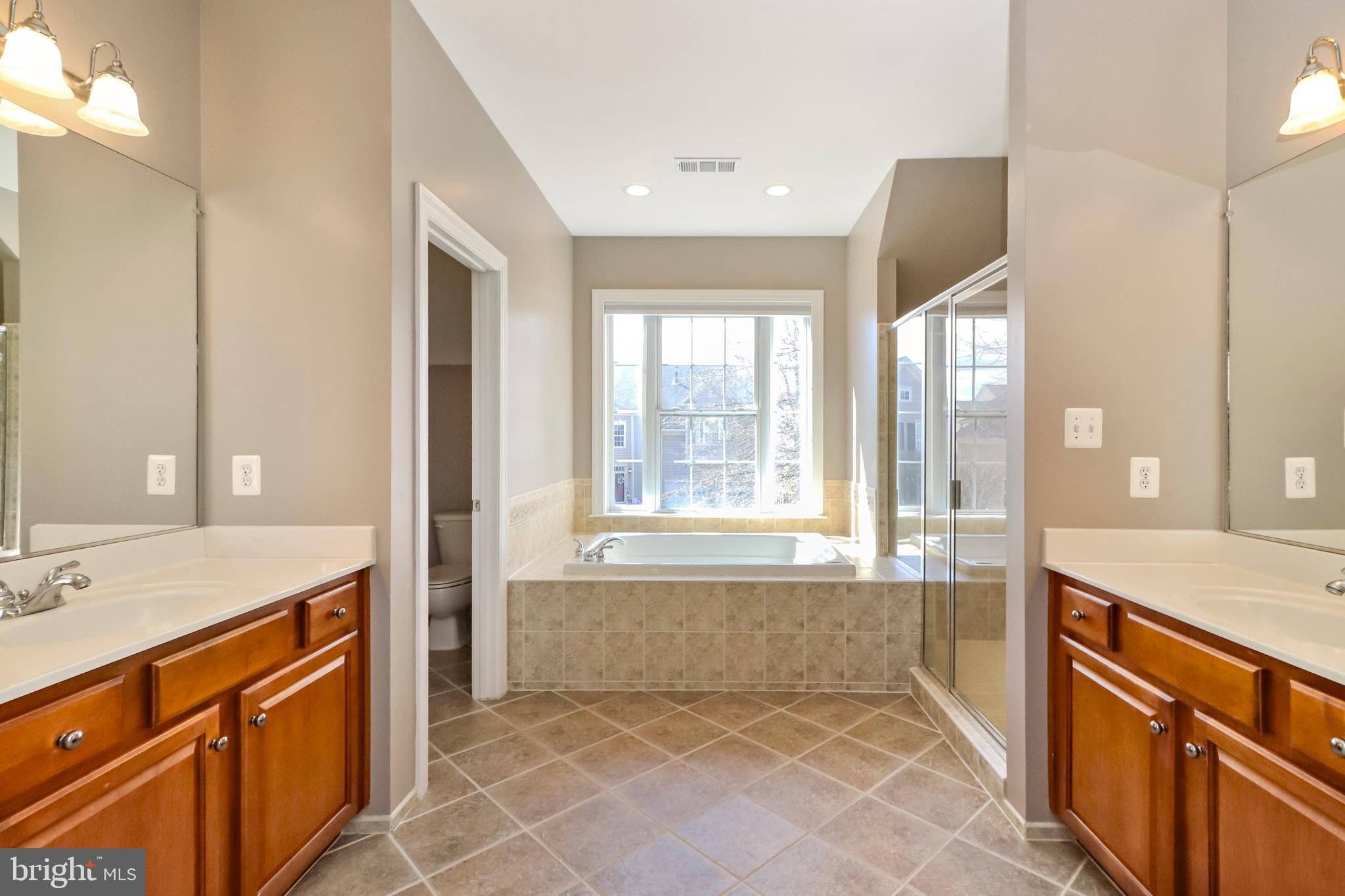 22773 Highcrest Circle Brambleton, VA 20148 - Photo 20 of 40 a spacious bathroom with a granite countertop bathtub sink and mirror